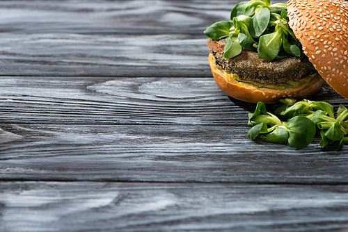 tasty vegan burger with microgreens served on wooden table