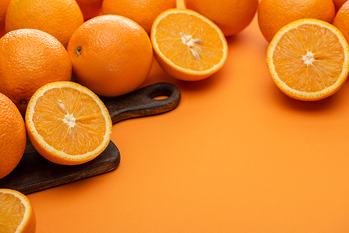 fresh juicy oranges on cutting board on colorful background