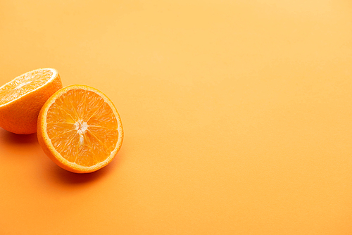 ripe delicious orange halves on colorful background