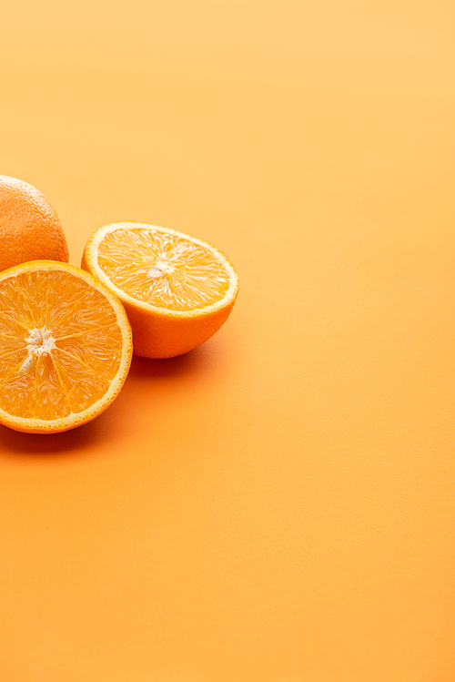 ripe delicious cut and whole oranges on colorful background