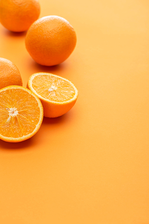 ripe delicious cut and whole oranges on colorful background