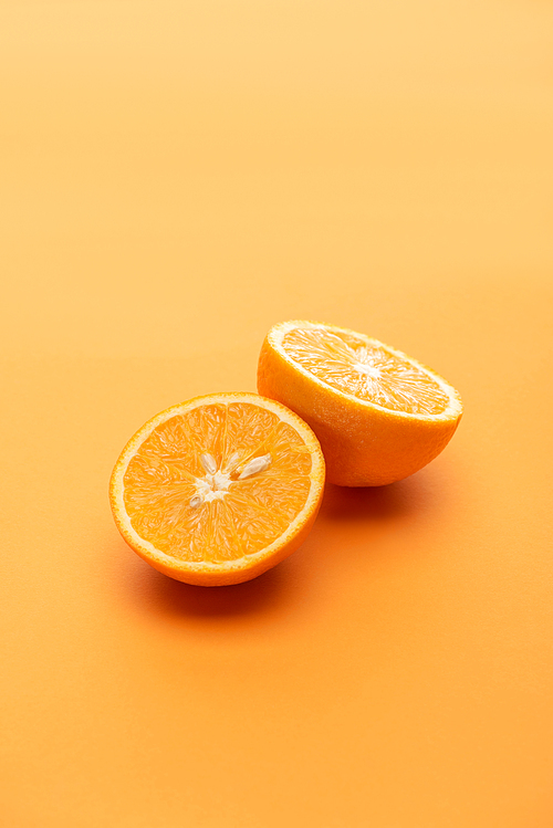 ripe juicy orange halves on colorful background