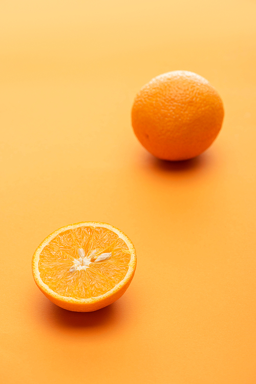 ripe juicy whole and cut oranges on colorful background
