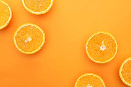 top view of ripe juicy orange slices on colorful background