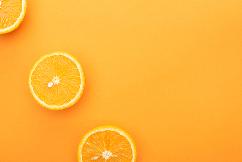 top view of ripe juicy orange slices on colorful background