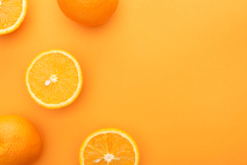 top view of ripe juicy whole oranges and slices on colorful background