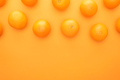 top view of ripe juicy whole oranges on colorful background