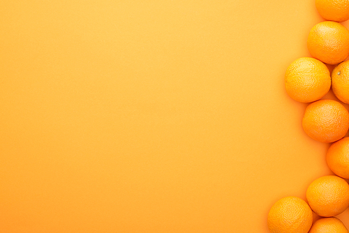 top view of ripe juicy whole oranges on colorful background