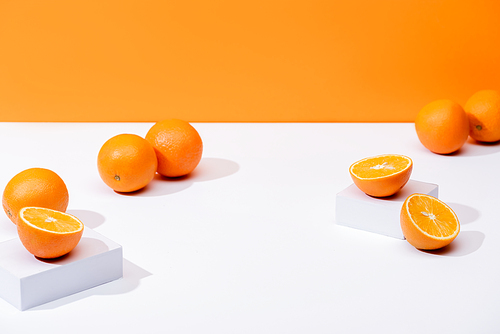 fresh ripe oranges on white surface isolated on orange