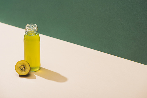 fresh juice near kiwi on green and white background