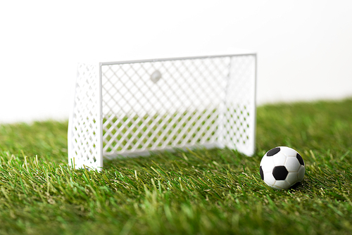 toy football gates and ball on green grass isolated on white, sports betting concept