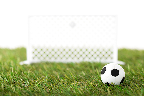 selective focus of toy soccer ball and football gates on green field isolated on white, sports betting concept