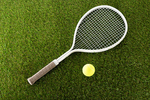 top view of tennis racket and ball on green grass, sports betting concept