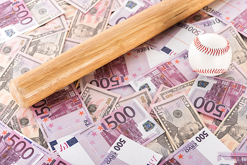 baseball bat and ball on euro and dollar banknotes, sports betting concept