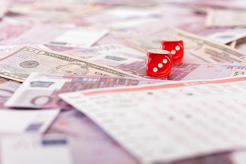 selective focus of dice near betting list on euro and dollar banknotes, sports betting concept