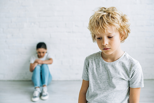 sad preteen brother and sister in t-shirts at home