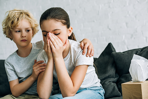 little brother consoling crying sister in living room