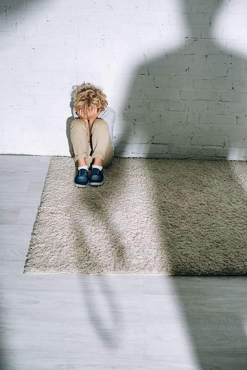 silhouette and scared little boy sitting on carpet