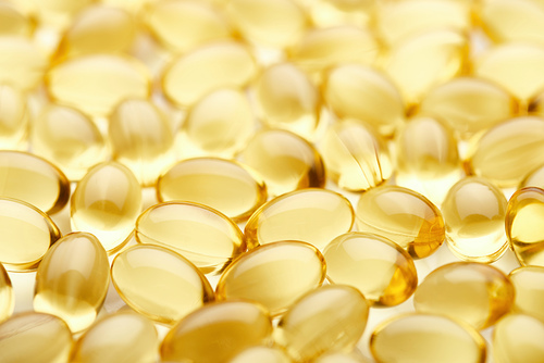 close up view of golden fish oil capsules