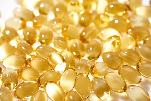 close up view of shiny golden fish oil capsules
