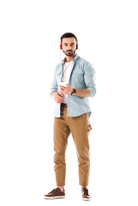 pensive man listening music in headphones and holding smartphone isolated on white