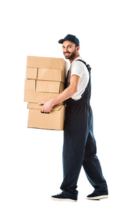 cheerful delivery man carrying cardboard boxes and  isolated on white