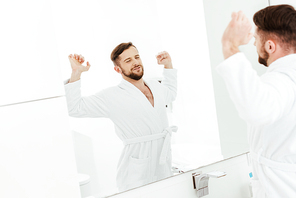 selective focus of happy bearded man stretching after wake up in bathroom