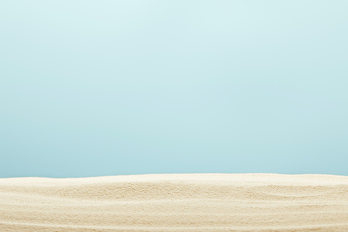 selective focus of golden and textured sandy beach isolated on blue