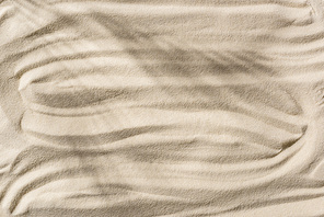 top view of beige sandy background with shadow and smooth waves