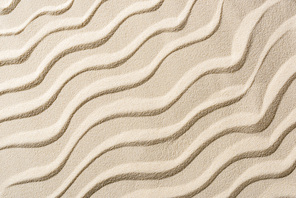 top view of beige sandy backdrop with smooth waves