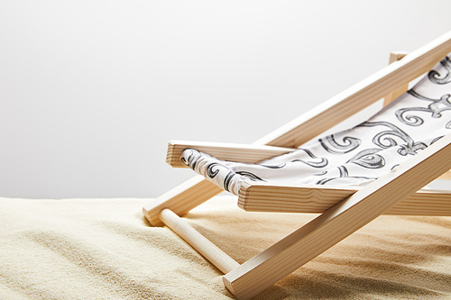 wooden deck chair on sand on grey background with copy space