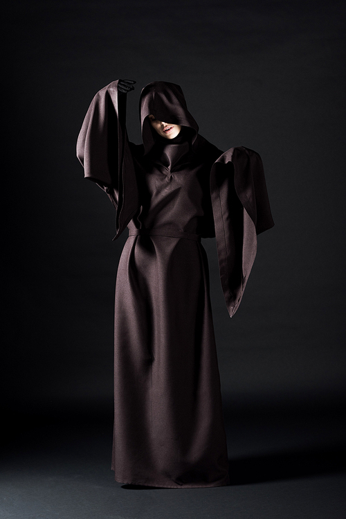 full length view of woman in death costume on black