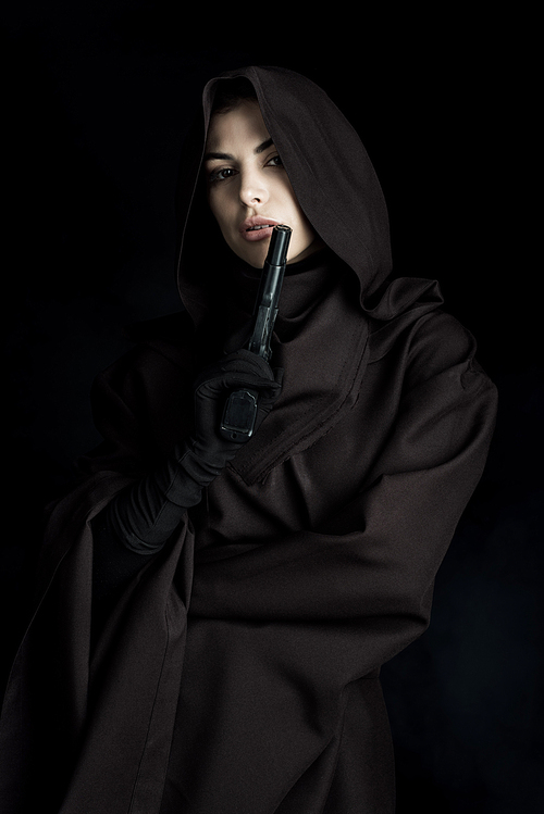beautiful woman in death costume holding gun isolated on black