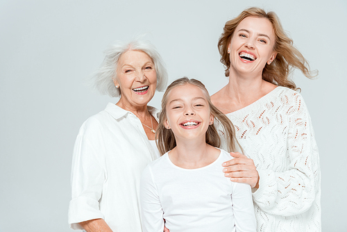 smiling granddaughter, mother and grandmother  isolated on grey
