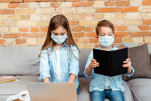 siblings in medical masks e-learning at home