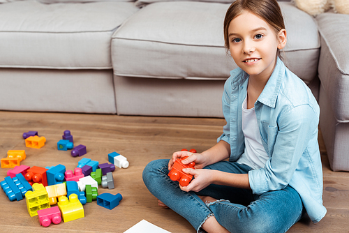 cheerful kid holding building blocks and 