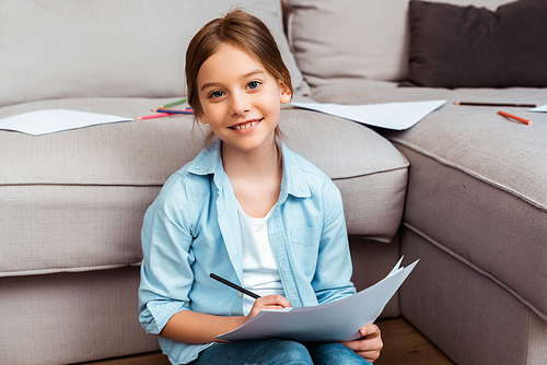 cute child smiling while drawing in living room