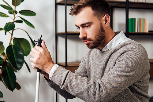 Upset blind man with walking stick in living room