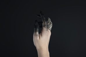 Cropped view of witch hand painted in black with jewelry ring isolated on black