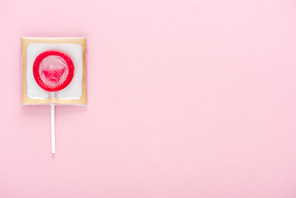 top view of condom wrapped as lollipop isolated on pink with copy space, Safe Sex concept