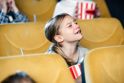 cute upset child crying while watching movie in cinema