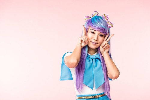 Pretty asian anime girl in purple wig showing peace signs isolated on pink