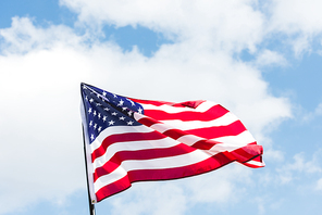 low angle view of flag with stars and stripes against blue sky