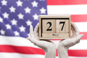 cropped view of female hands painted in white holding cubes with date near american flag