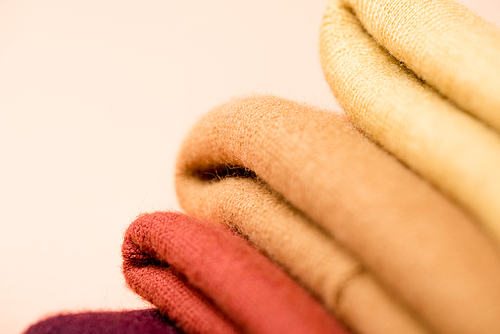 selective focus of folded colorful clothes isolated on light