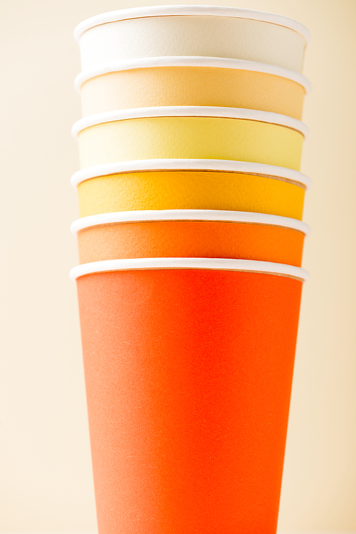 bright colorful disposable cups isolated on beige background