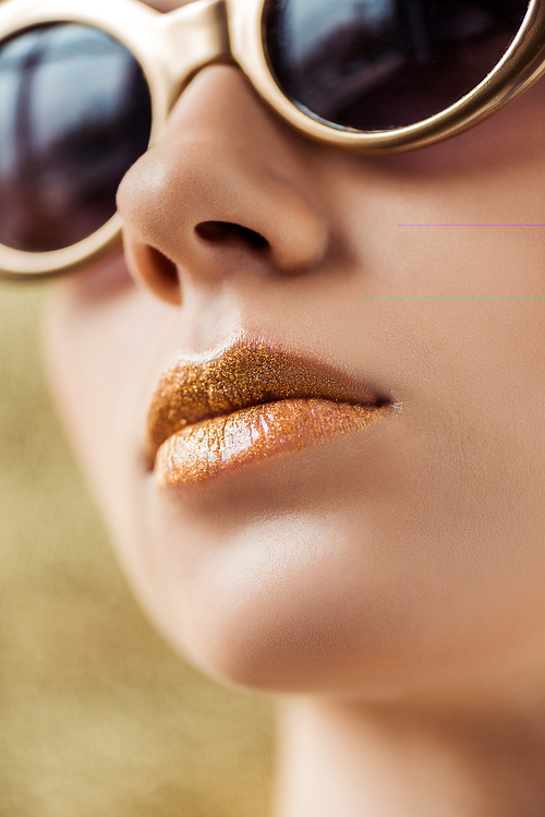 young beautiful woman in sunglasses with shiny golden lips