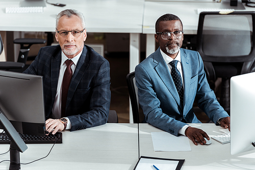 handsome african american businessman near coworker in office