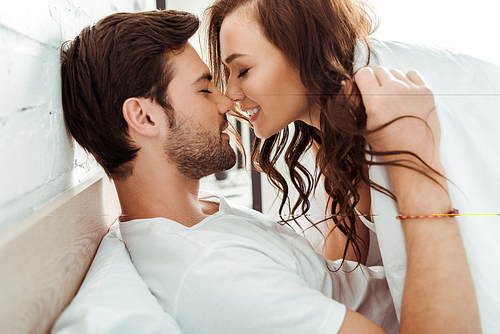 happy young woman with closed eyes near cheerful boyfriend