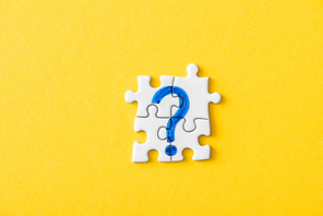 top view of connected puzzle pieces with drawn blue question mark on yellow